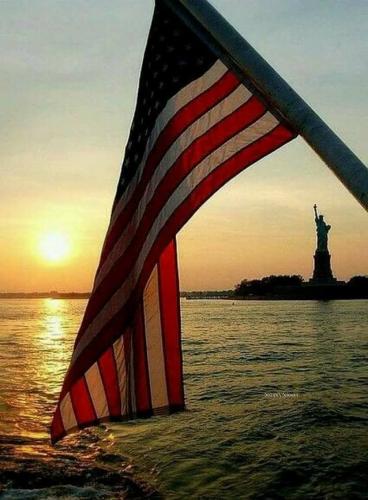 Flag - At Statue of Liberty at sunset
