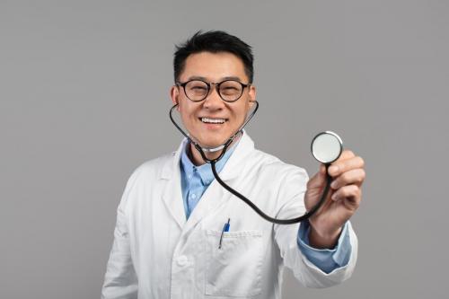 cheerful-confident-mature-japanese-doctor-white-coat-glasses-listens-camera-with-stethoscope_116547-27032