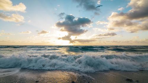 Waves breaking on the beach at sunrise somewhere