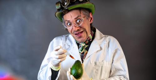 Maniac steampunk scientist with a hypodermic syringe and a crazy smile injects poison into avacado_cr