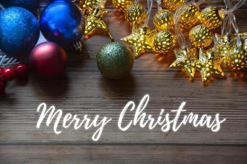merry-christmas-text-with-christmas-light-and-decorations-background-christmas-and-season-s-greetings-concept-photo